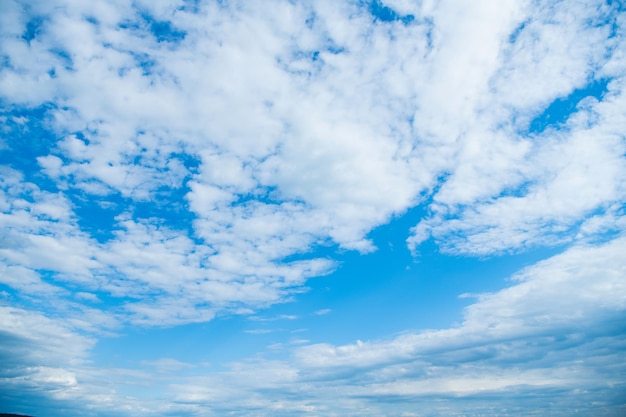 Blue skyscape background with white fluffy clouds