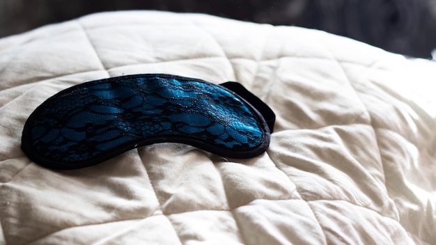 Photo blue sleep mask on a white pillow