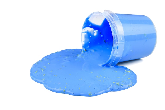 The blue slime flows out of the plastic bucket isolated on a white background. Stress reliever toy.