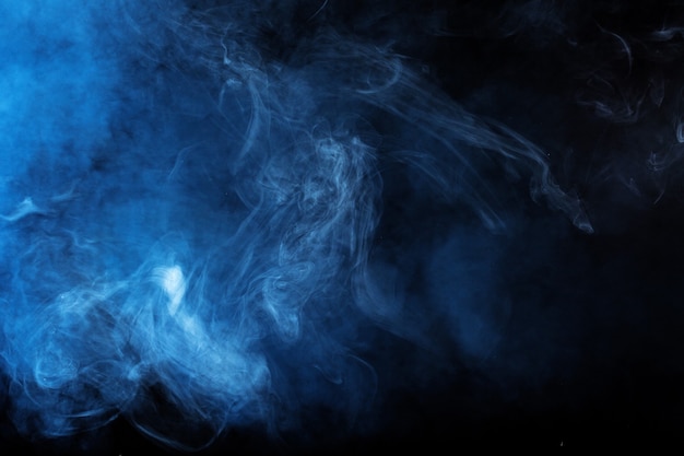 Blue smoke over black studio background