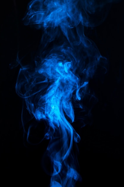 Blue smoke swirling around against a black background