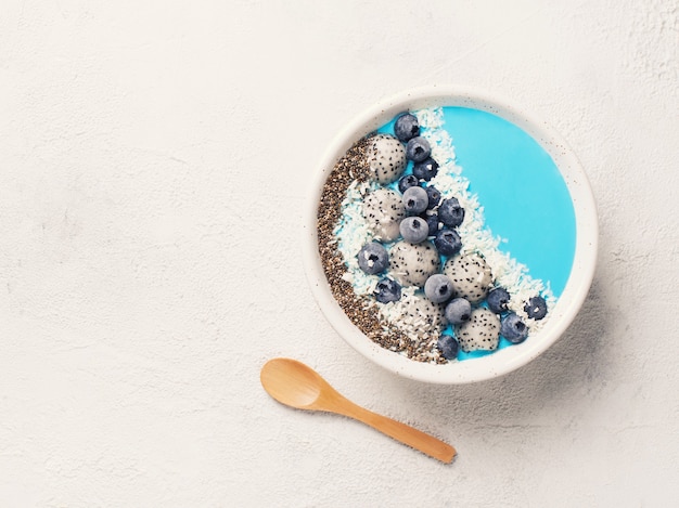 Blue smothie in bowl with granola and berries 