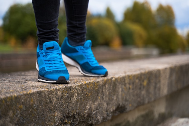 Фото Синие кроссовки на ногах женщины.