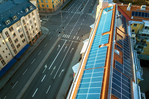 blue solar photo voltaic panels system on high apartment building roof top on sunny day