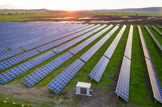 ブルーソーラー太陽光発電パネルシステムは、農村景観と夕日に再生可能なクリーンエネルギーを生成します。