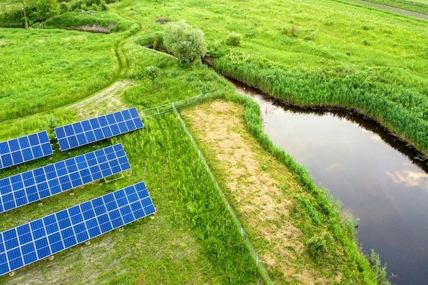 Blue solar photovoltaic panels mounted on metal frame standing on ground