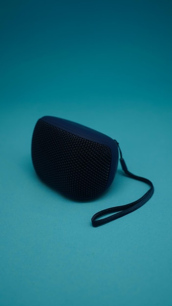 A blue speaker that is on a blue background