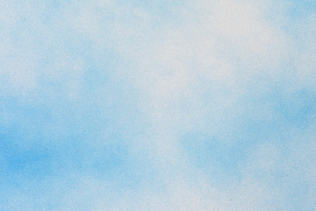 Синяя аэрозольная краска на фоне белой бумаги
