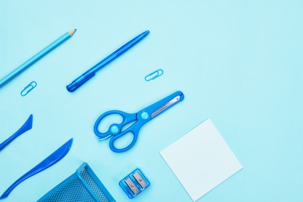 blue stationery on blue background school, copyspace