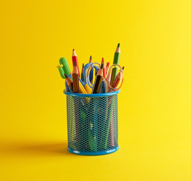 Голубой канцелярский стакан с разноцветными деревянными карандашами