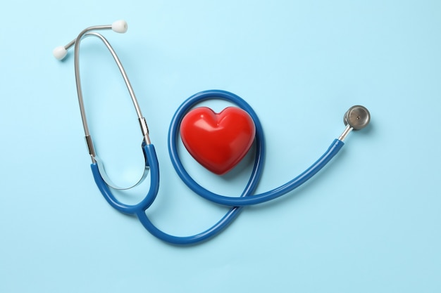 Blue stethoscope and heart on blue surface