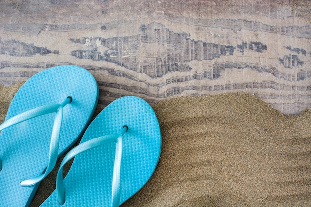 Blue summer shoes on sand top view copy space