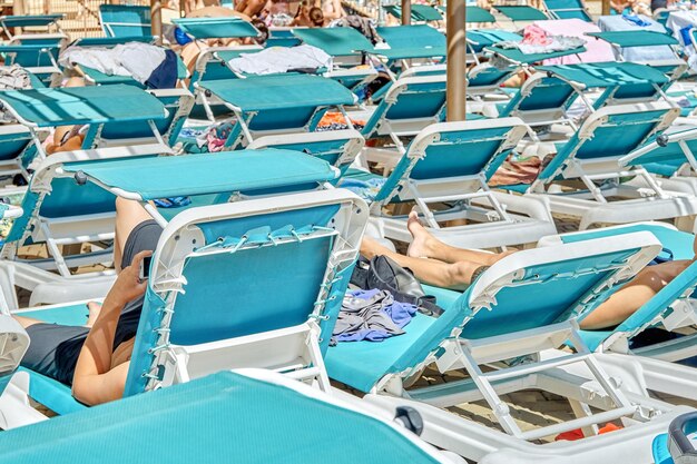 Blue sun loungers put in rows under transparent canopy near swimming pool in touristic water park