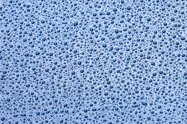 Blue surface with drops of rain water