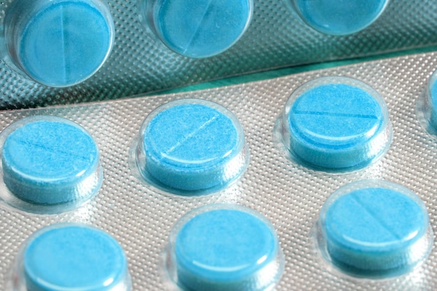 Blue tablets in a close-up blister. medical drugs