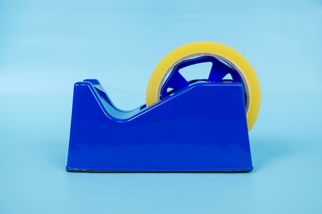 Blue tape dispenser with transparent tape isolated on blue background