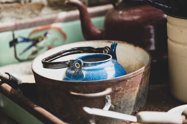 Photo blue teapot in rusty stewpan.