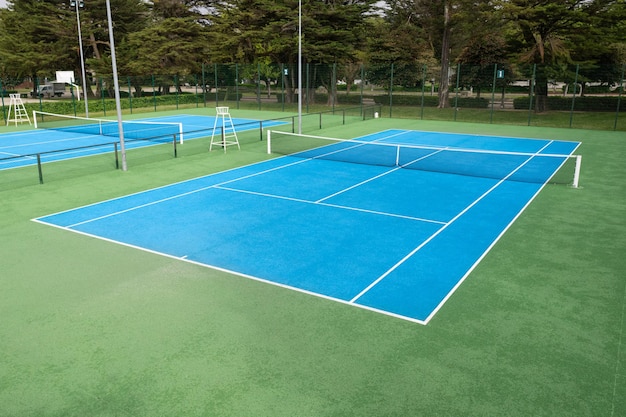 Blue tennis court on a public park no people