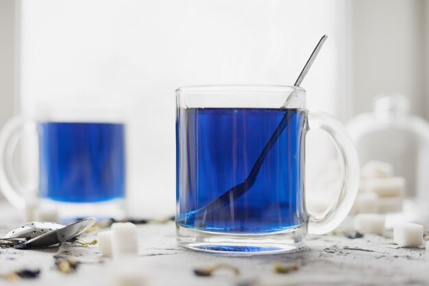 Blue Thai Anchan tea in a glass mug.