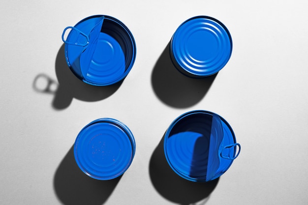 Photo blue tin can on gray surface with shadow