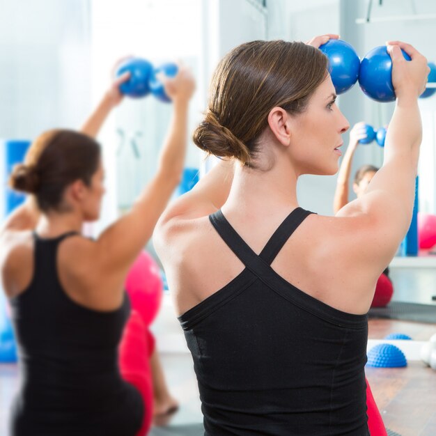  blue toning ball in women pilates class rear view