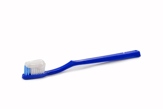 Blue toothbrush with toothpaste in her hand isolated on white