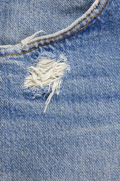 Текстура джинсов синий рваный деним.