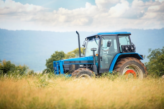 A blue tractor working on farm land 