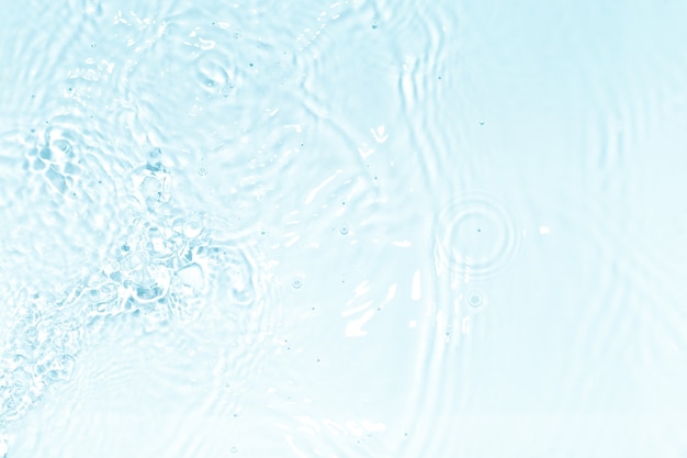 Photo blue, transparent and clear water surface with splashes and little bubbles. water texture. close up view. trendy abstract nature background.
