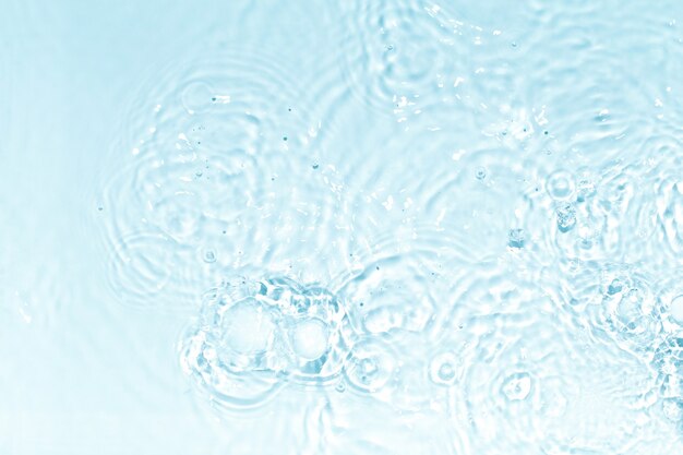Photo blue, transparent and clear water surface with splashes and little bubbles. water texture. close up view. trendy abstract nature background.