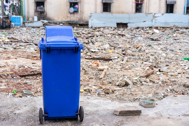 Blue trashcan with old building 