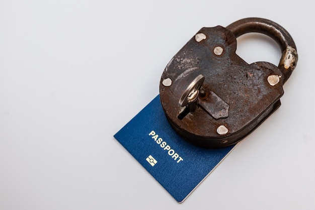 흰색 배경에 열쇠가 있는 자물쇠로 잠긴 파란색 여행 여권 코로나바이러스 및 여행 개념