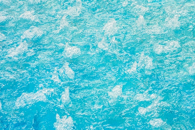 Голубая бирюзовая вода в бурлящем бассейне с текстурой гидромассажа на фоне чистой воды