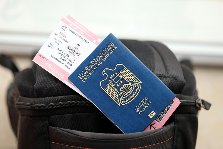 Blue united arab emirates passport with airline tickets on touristic backpack