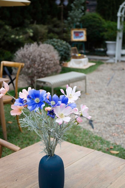 A blue vase with flowers on a table