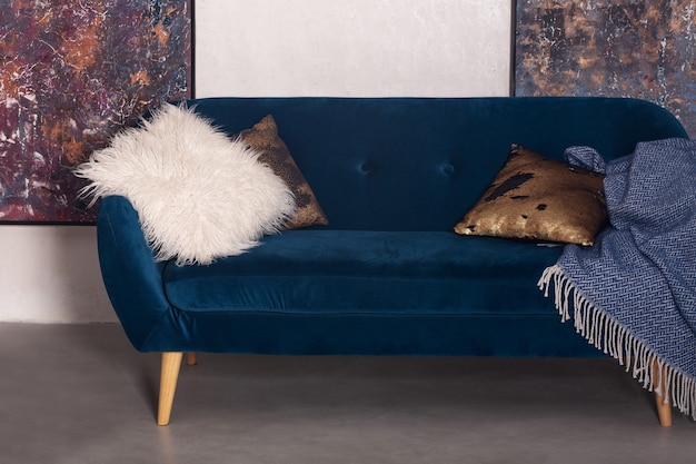 Blue velvet sofa with pillows in the flat interior