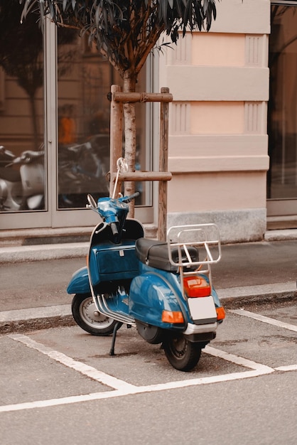 A blue vespa parked in a parking lot