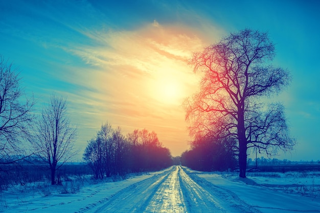 Blue vintage winter snowy rural landscape at sunset