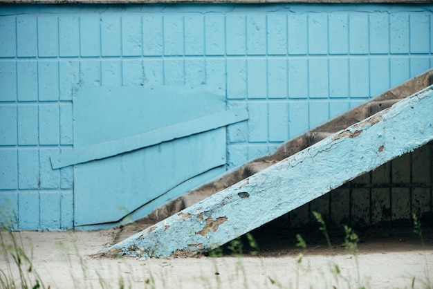 Синяя стена здания с люком и лестницей