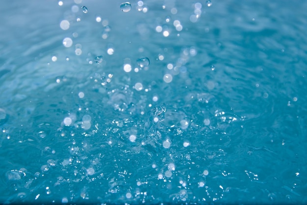 Голубая вода выглядит свежей с пузырьками и водой.