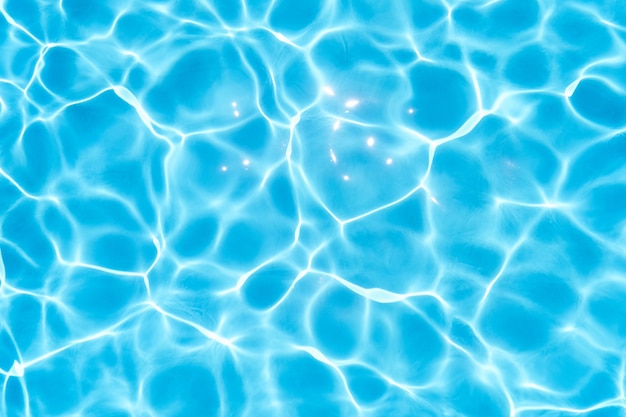 Blue water in the pool glows under the rays of the sun closeup