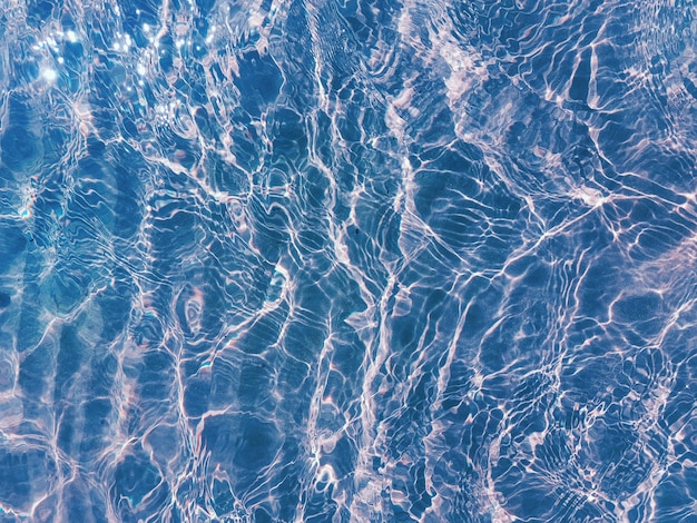 Поверхность голубой воды, вид сверху на открытом море, отражение солнца на открытом воздухе, тусклый фон поверхности