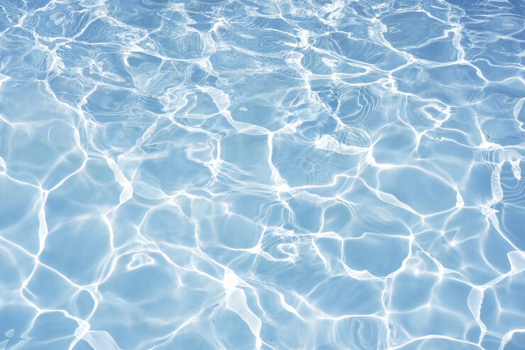 明るい太陽の光の反射、スイミングプールのバックグラウンドでの水と青い水面