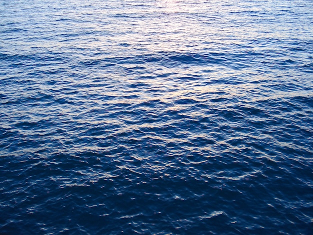 Blue water surface with waves and ripples