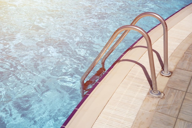 Blue water in swimming pool outdoors under the shiny sunlight