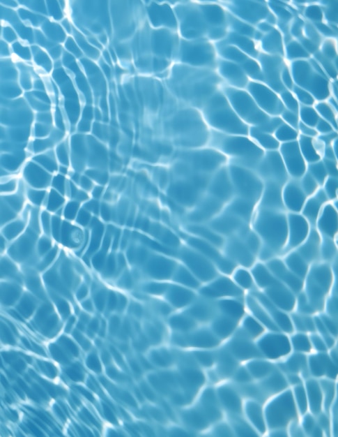 Blue water in a swimming pool with ripples and the sun reflecting on the surface.