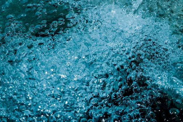 Photo the blue water that creates many small bubbles inside gives a fresh and ripple feel, suitable for design and background.