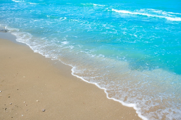 Foto onda di acqua blu sulla sabbia della spiaggia