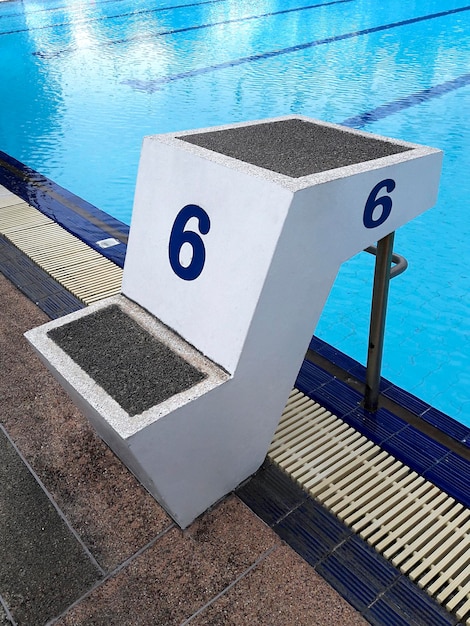 Blue water wave in swimming pool reflects with sunlight blue tile ceramic to swimming race and water sports