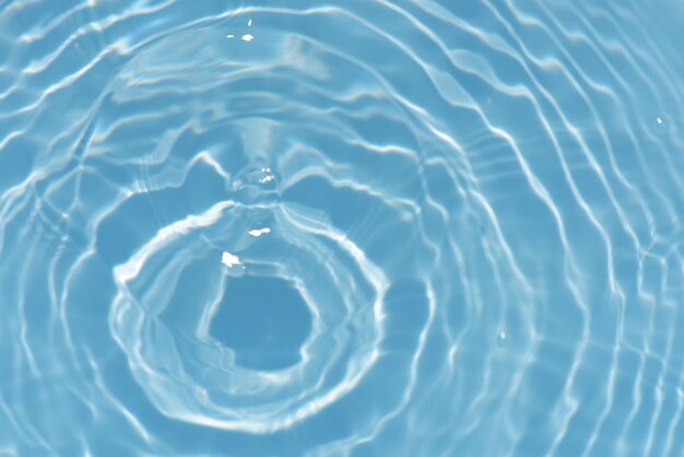 水面に波紋のある青い水 ぼやけた透明な青い色の澄んだ穏やかな水